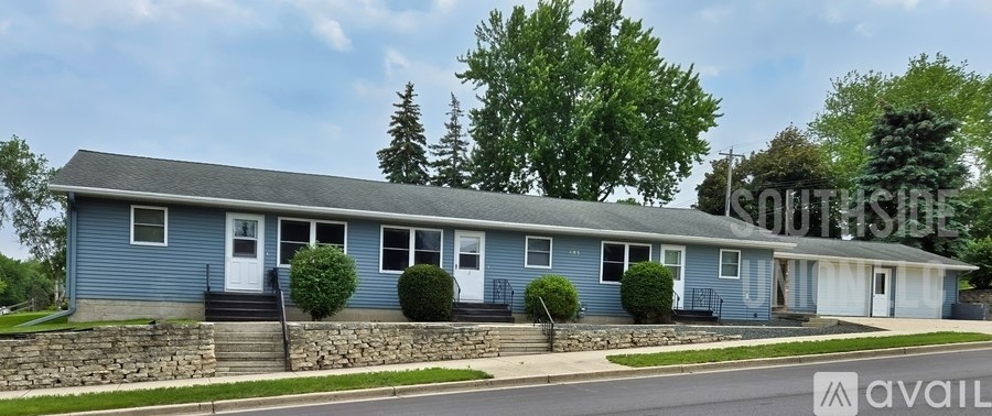 A blue house with a white door and windows is for sale.