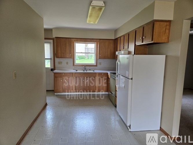 A kitchen with a white fridge and wooden cabinets.