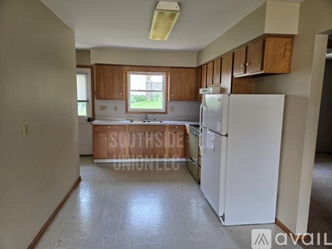 A kitchen with a white fridge and wooden cabinets.