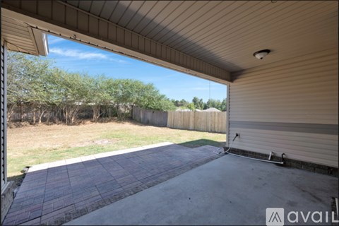 A patio area with a brick floor and a covered area with a sliding door.