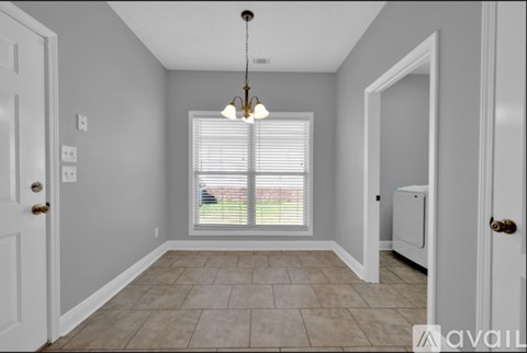 A room with a tiled floor and a window with blinds.