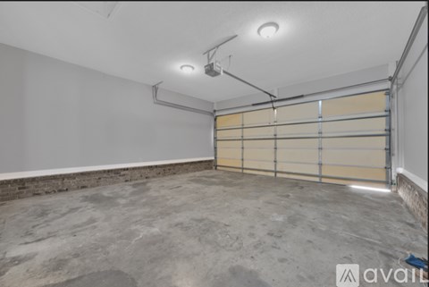 A room with a garage door and a ceiling fan.
