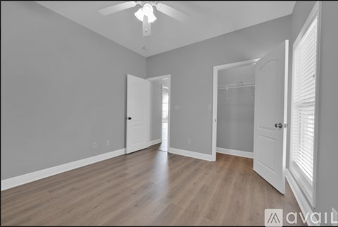 A spacious room with wooden floors and white walls.