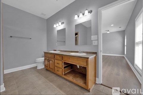 A bathroom with a wooden vanity and a mirror above it.