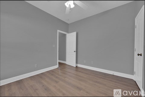 A room with a white door and a light on the ceiling.