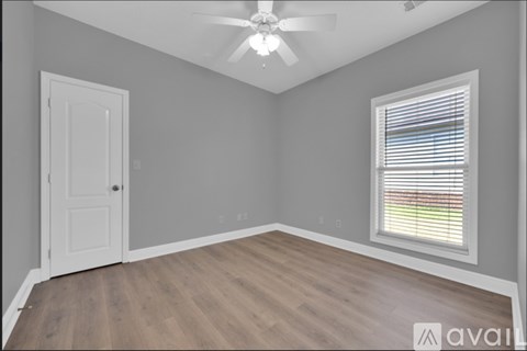 A room with a ceiling fan and a window with blinds.