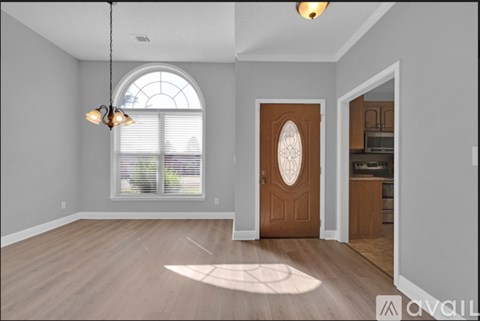 A room with a wooden door and a window with blinds.