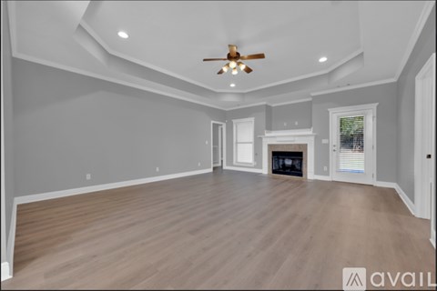 A spacious room with a fireplace and a ceiling fan.