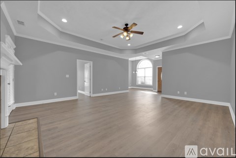 A spacious room with a ceiling fan and lighting fixtures.