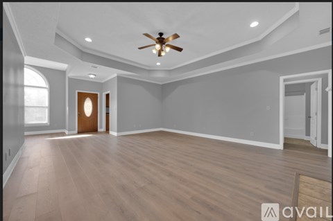 A spacious room with a ceiling fan and lighting fixtures.