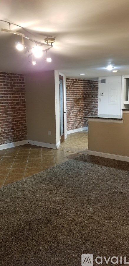 A room with a brick wall and a carpeted floor.