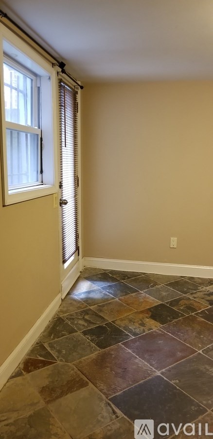 A room with a window and tiled floor.