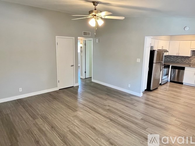 A room with a ceiling fan and wooden flooring.