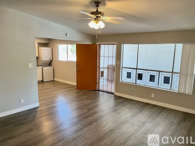 A room with a ceiling fan and wooden flooring.