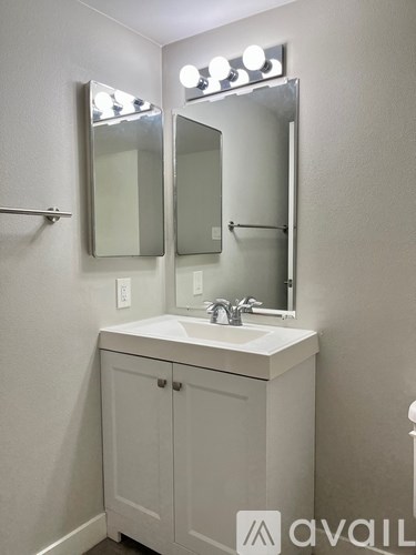 A bathroom vanity with a mirror and lights above it.