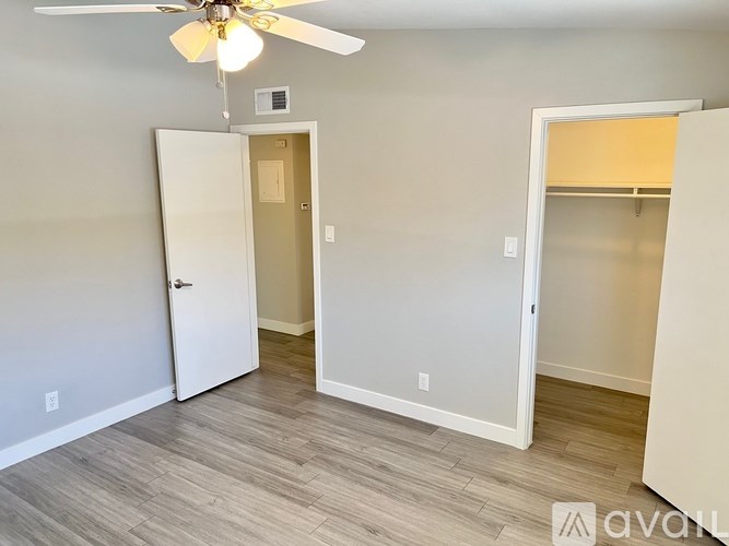 A room with a ceiling fan and two doors.
