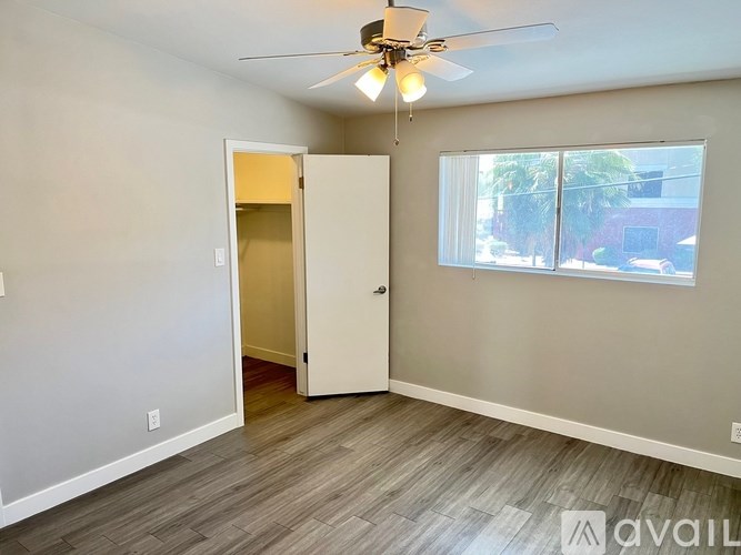 A room with a ceiling fan and a door leading to another room.