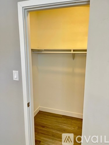 A room with a white door and a light switch on the wall.