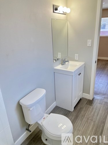 A white toilet with a white sink and a mirror above it.