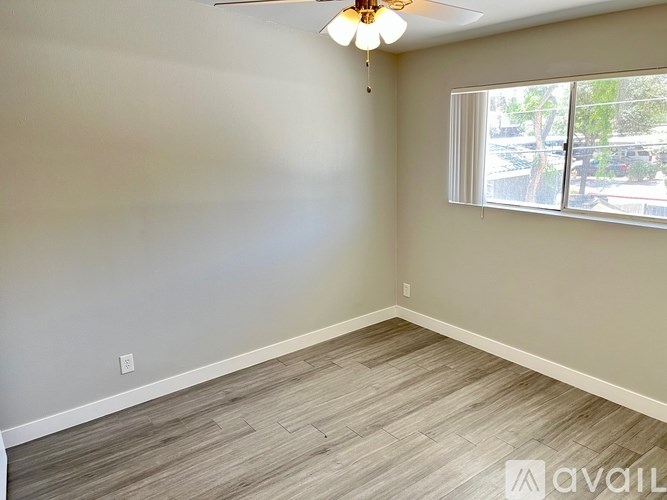 A room with a ceiling fan and a window.