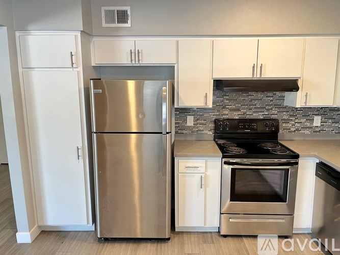 A modern kitchen with a stainless steel refrigerator and oven.