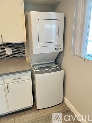 A white dishwasher is built into a kitchen cabinet.