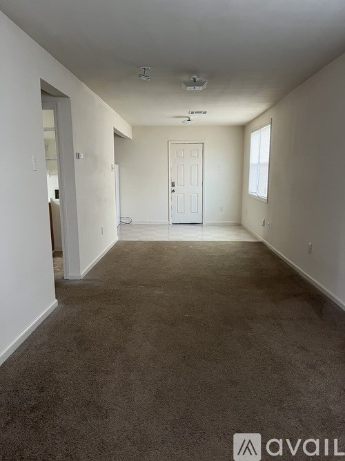 A carpeted hallway with a door at the end.
