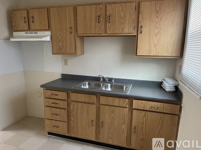 A kitchen with wooden cabinets and a black countertop.