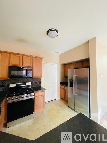 A kitchen with wooden cabinets and a black stove top oven.
