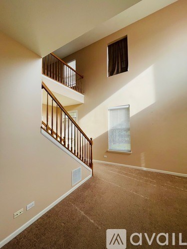 A carpeted staircase with a railing leads to a second floor.