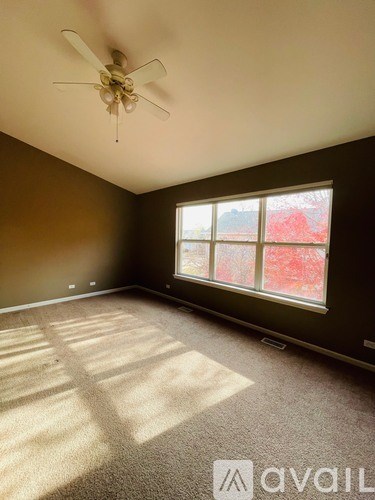 A room with a ceiling fan and a window.