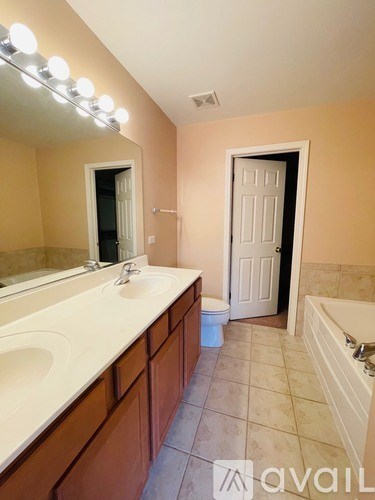 A bathroom with a vanity, toilet, and a door.