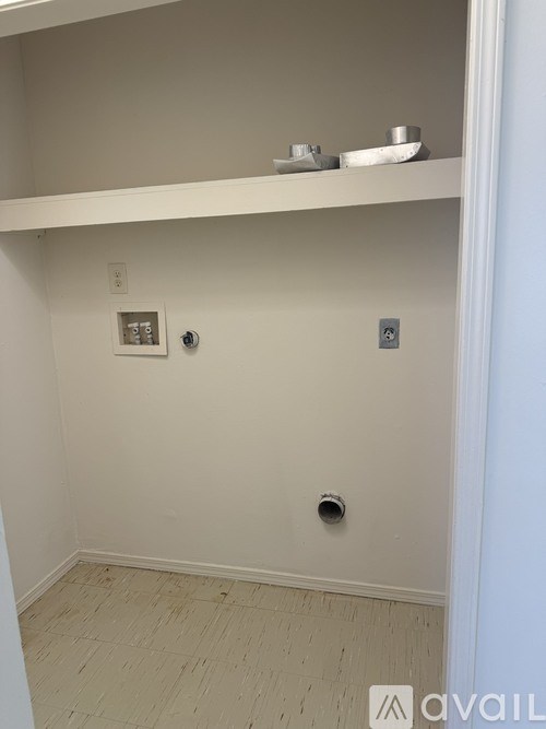 A white wall with a shelf and a light switch.