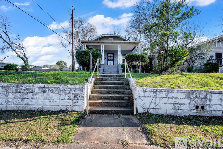 A house with a front yard and stairs leading to the front door.