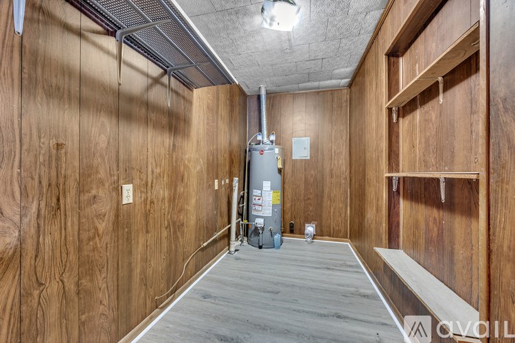 A wood panelled room with a heating unit in the corner.