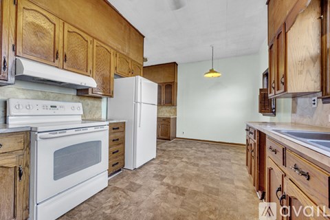 A kitchen with wooden cabinets and white appliances.