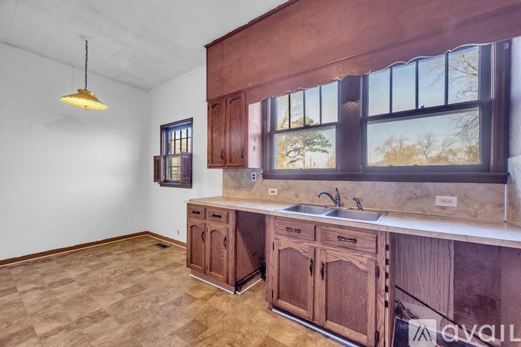 A kitchen with wooden cabinets and a window.