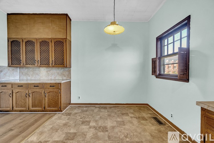 A room with wooden floors and a window with blinds.