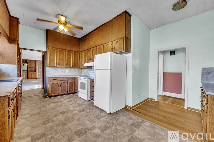A kitchen with wooden cabinets and a white refrigerator.