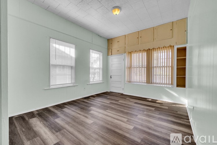 A room with wooden flooring and a white door.