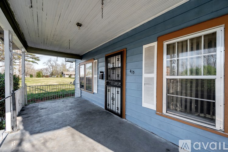 A porch with a black railing and a white ceiling.