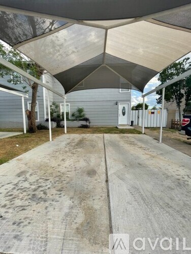 A covered walkway with a white canopy and a concrete floor.