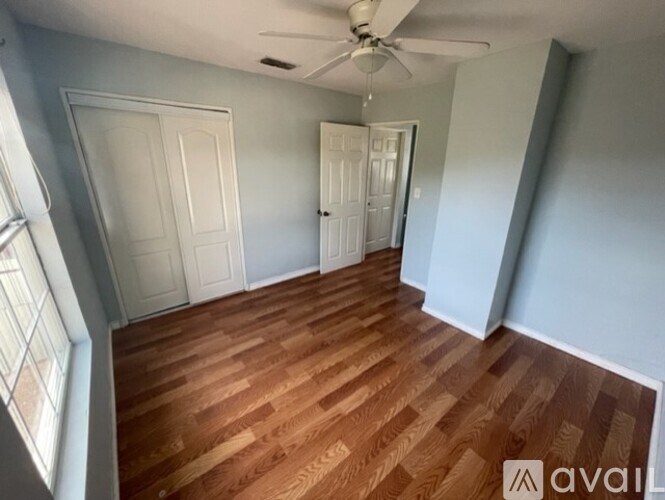 A room with wooden flooring and a ceiling fan.