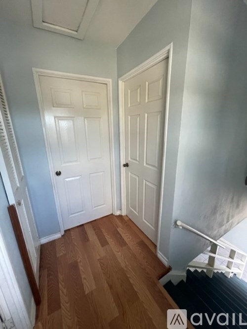 A hallway with two doors and a staircase.