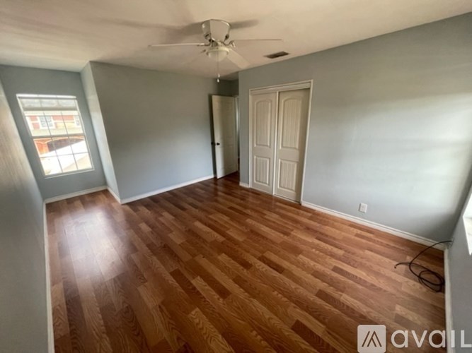 A room with wooden flooring and a ceiling fan.