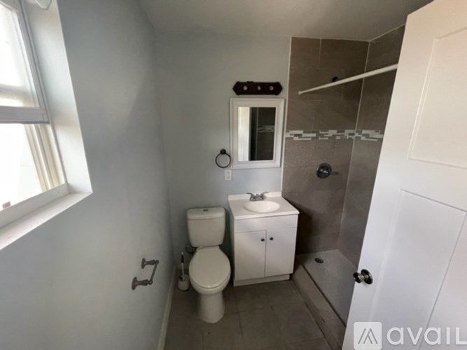 A bathroom with a toilet, sink, and shower.