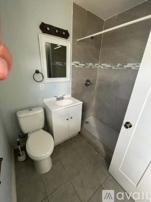 A bathroom with a toilet, sink, and shower.