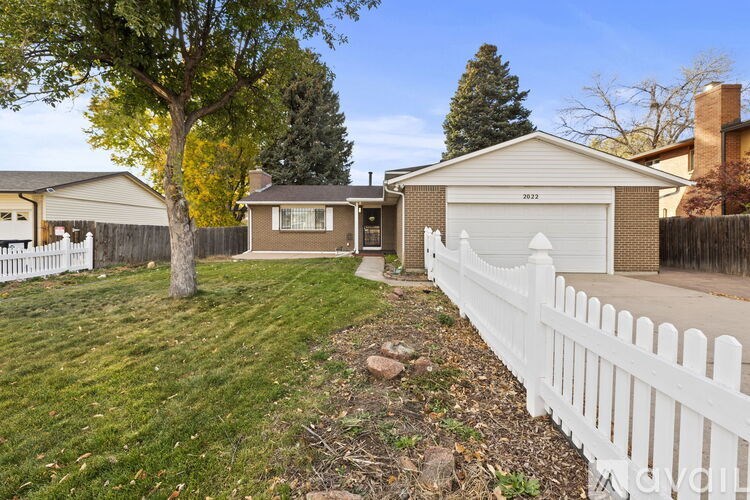 A house with a white picket fence in front of it.