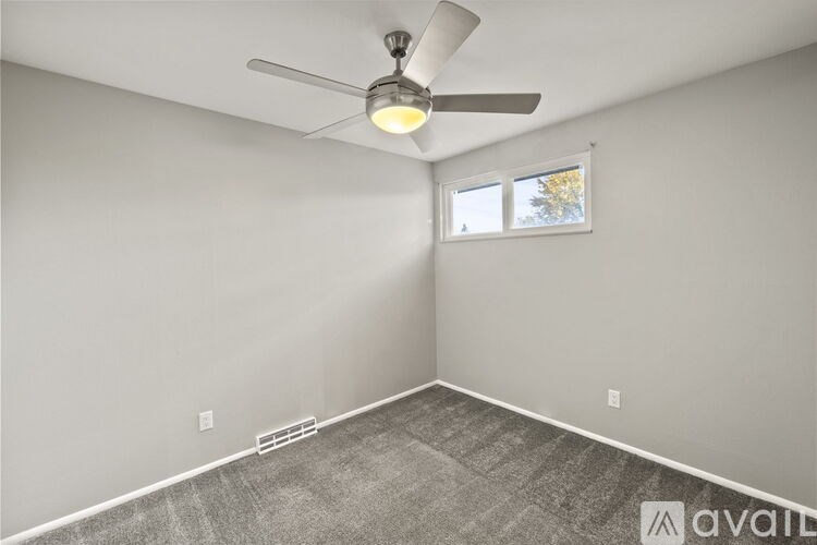 A room with a ceiling fan and a window.