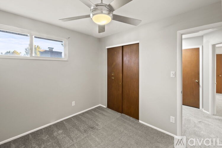 A room with a ceiling fan and two doors.